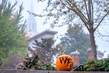 A pumpkin carved with the WF logo stands on a wall outside Hearn Plaza, on the campus of Wake Forest University, Thursday, October 15, 2020.
