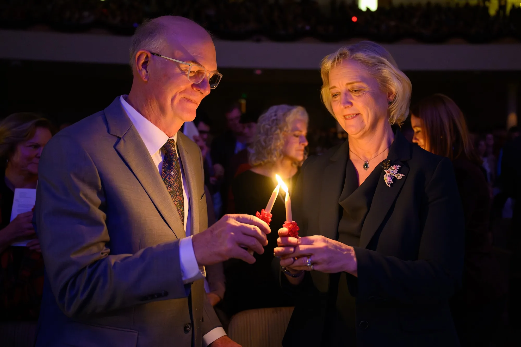 Wente lights a candle with her husband, geneticist Chris Hardy, Ph.D., at the 2024 Lovefeast in Wait Chapel.