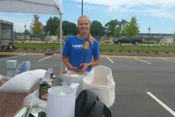 Anna Anstey (’26) holds a lamp during a pop-up shop for her business, Campus Reclaimed.