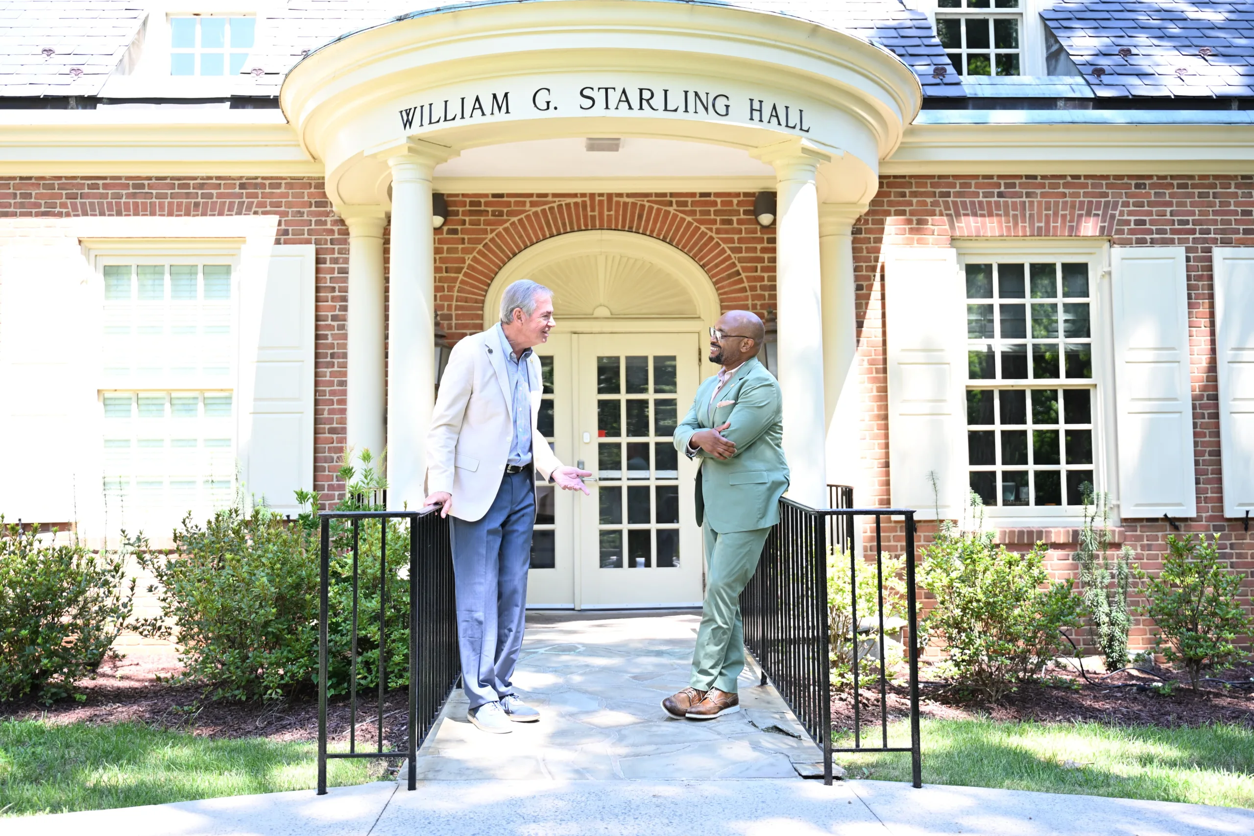 From left, Tom Dingledine (MBA ’78) is having a conversation with Chad Cheek (MBA '05) in front of Starling Hall.