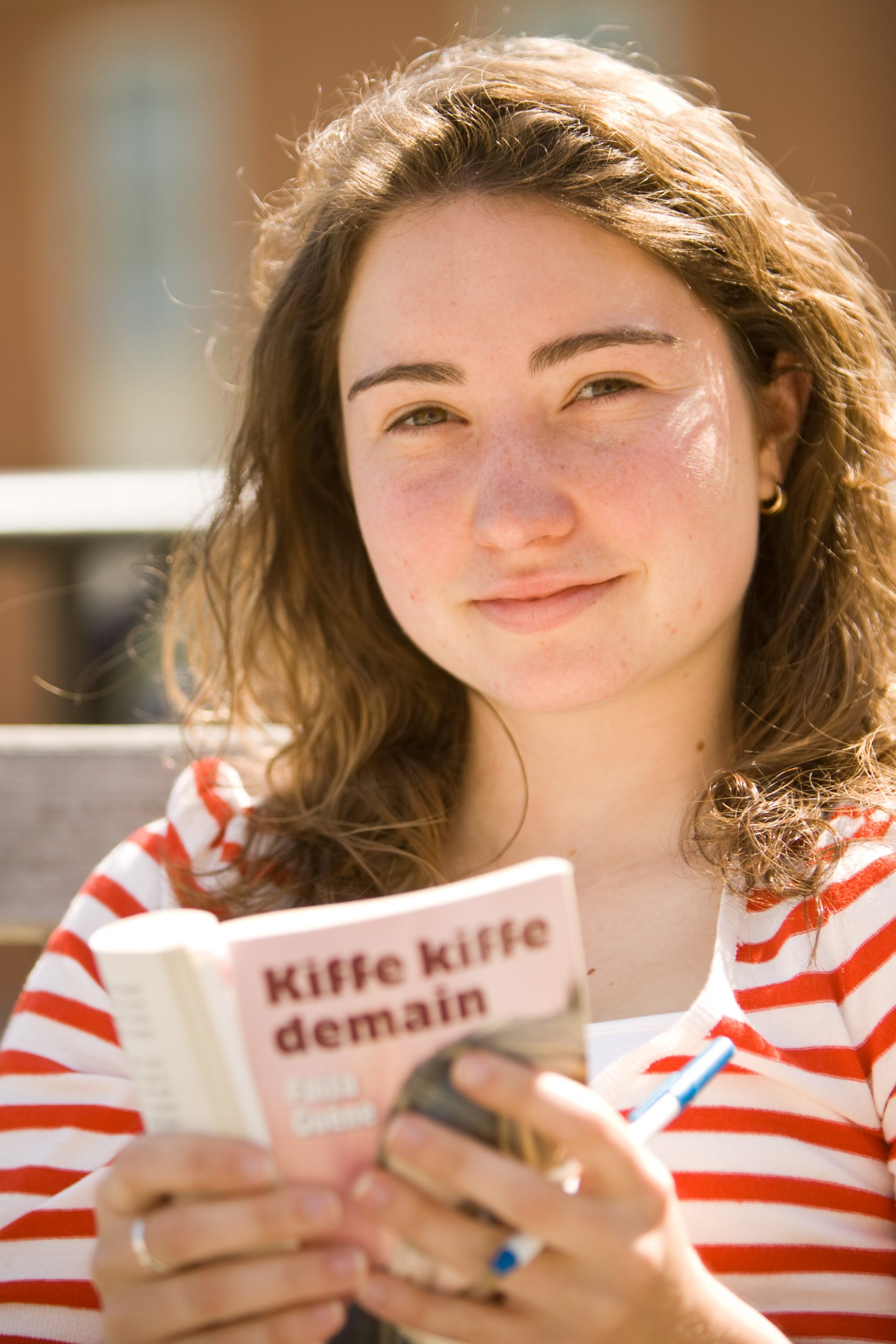A student reading Kiffe kiffe demain outdoors