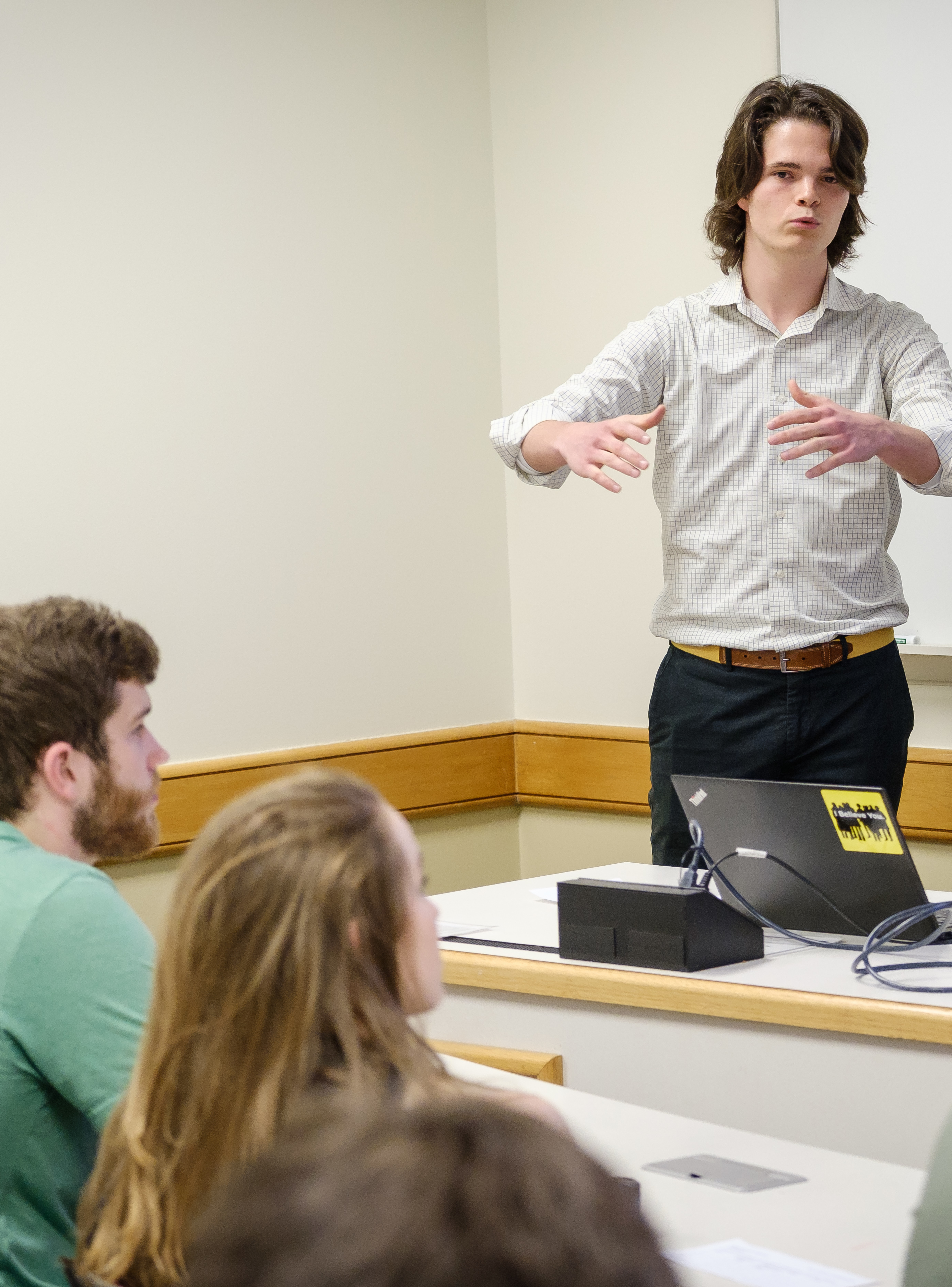A student gives a presentation to other student in French
