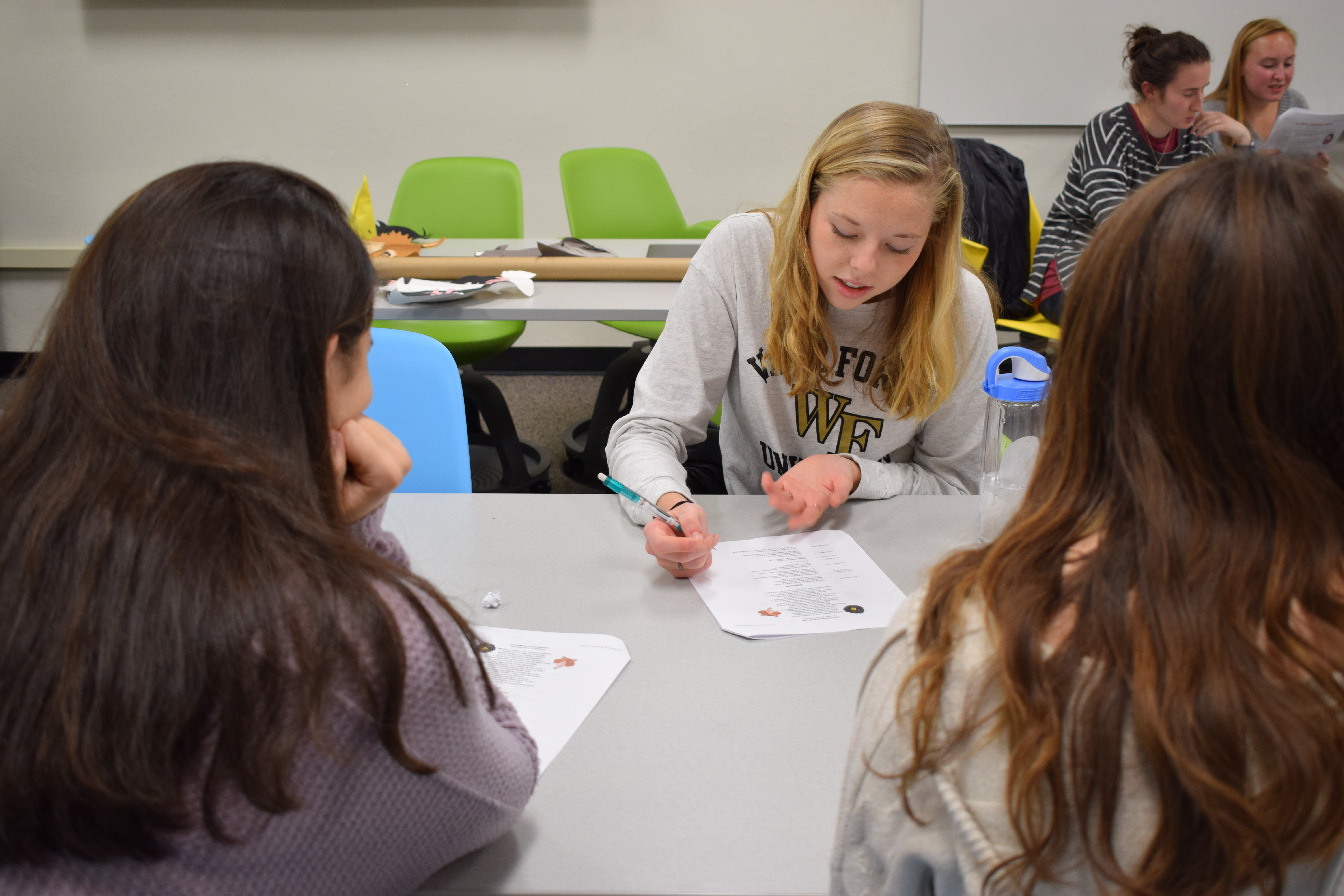 Three students working on a worksheet together in French class