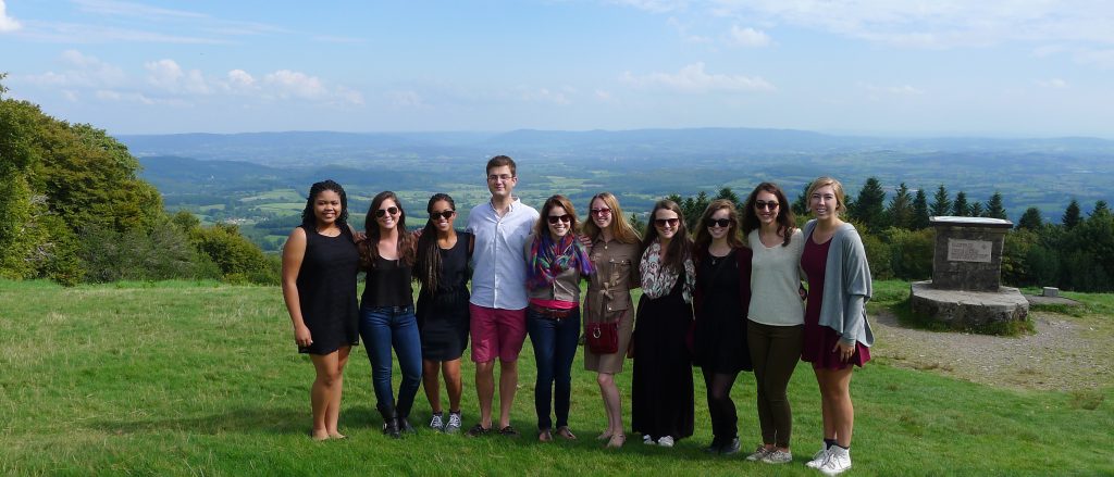 Ten students standing together on a hill overlooking the beautiful French countryside