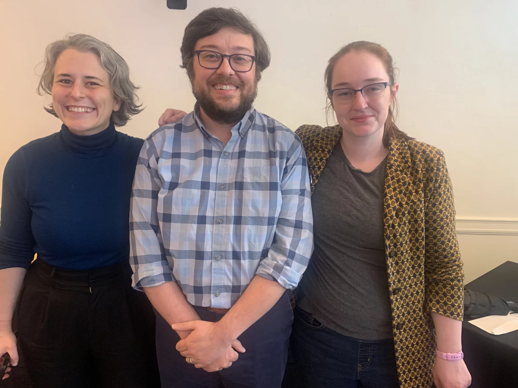 Three people stand in a row in front of a blank wall, smiling. They are Dr. Cole, Dr. Sali, and Dr. Garrison at their tenure and promotion celebration in Spring 2026.