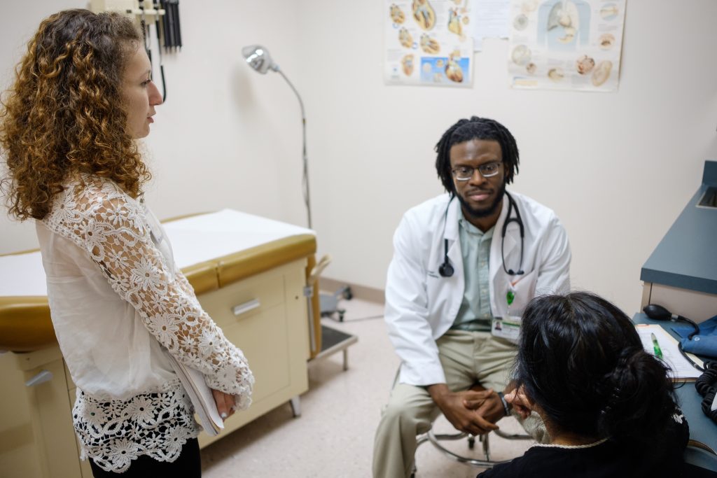 An ITS student translator assists a doctor and patient inside a doctor's office. Spanish Concentrations