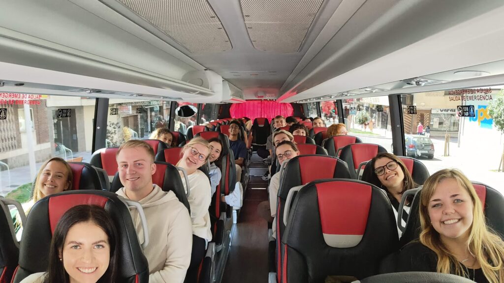 Students smiling on a full tour bus in Salamanca, Spain.