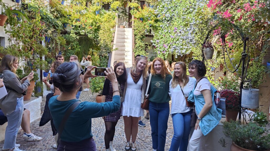 Professor Irma Alarcón takes a photo of students posing outside in Salamanca, Spain.