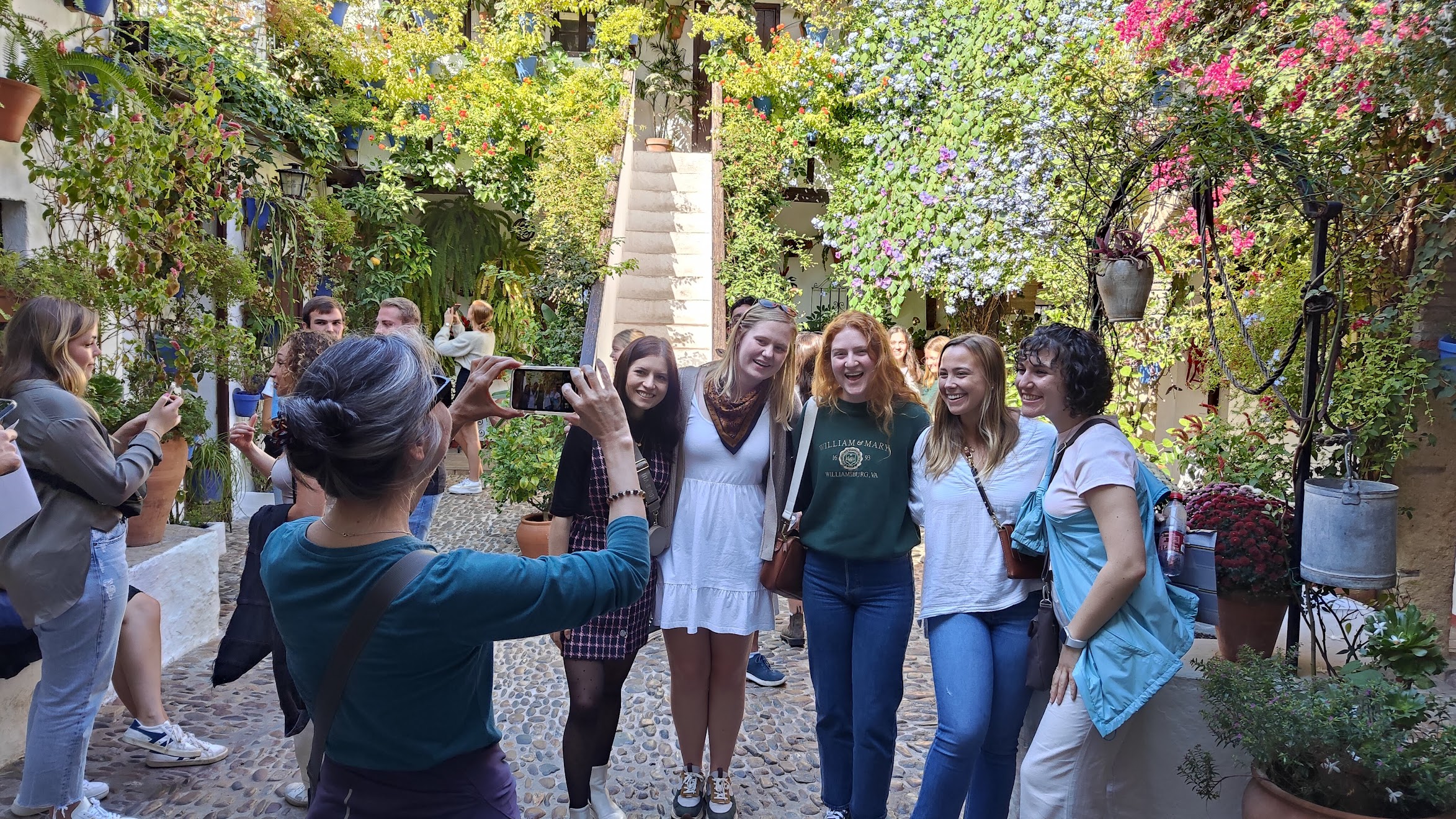 Professor Irma Alarcón takes a photo of students posing outside in Salamanca, Spain.