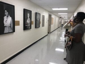 Photo from the portrait unveiling event showing people at the event looking at the paintings