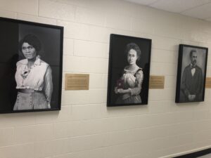 Photo from the portrait unveiling event showing the paintings on the wall