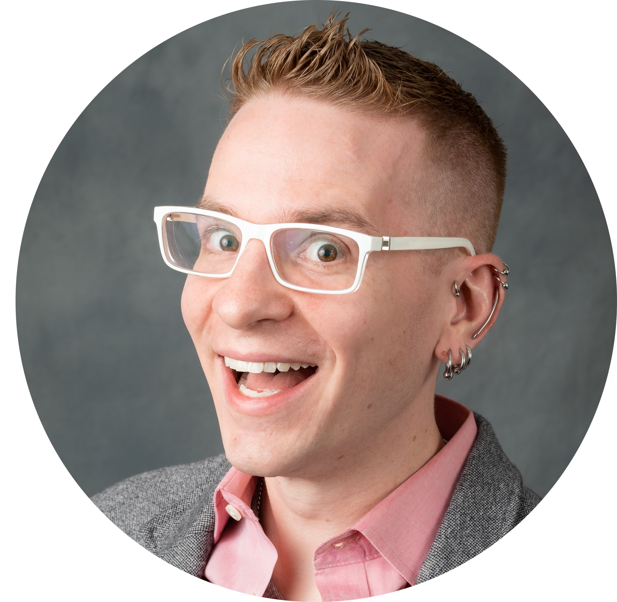 Profile picture of T. H. M. Gellar-Goad: a white man with short brown hair, white glasses, ear piercings, and a goofy smile. He's wearing a pink button-up shirt and a gray sport coat.
