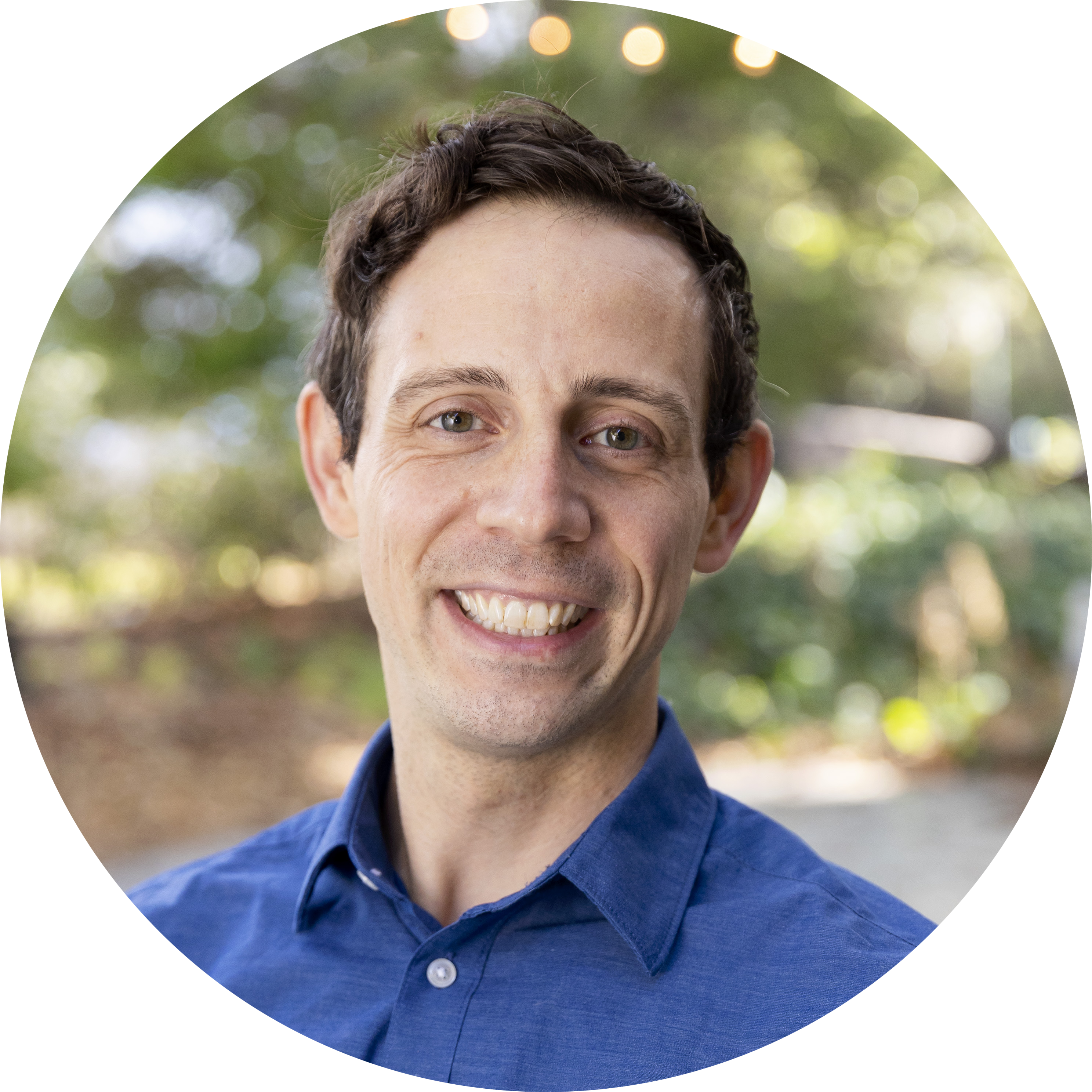 Profile picture of Alexander Creighton: a white man with brown hair. He is smiling and wearing a true blue button-up shirt.