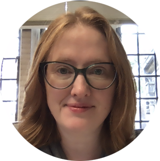 Profile picture of Lauren Donovan Ginsberg: a white woman with auburn hair and large black glasses. She is half-smiling.