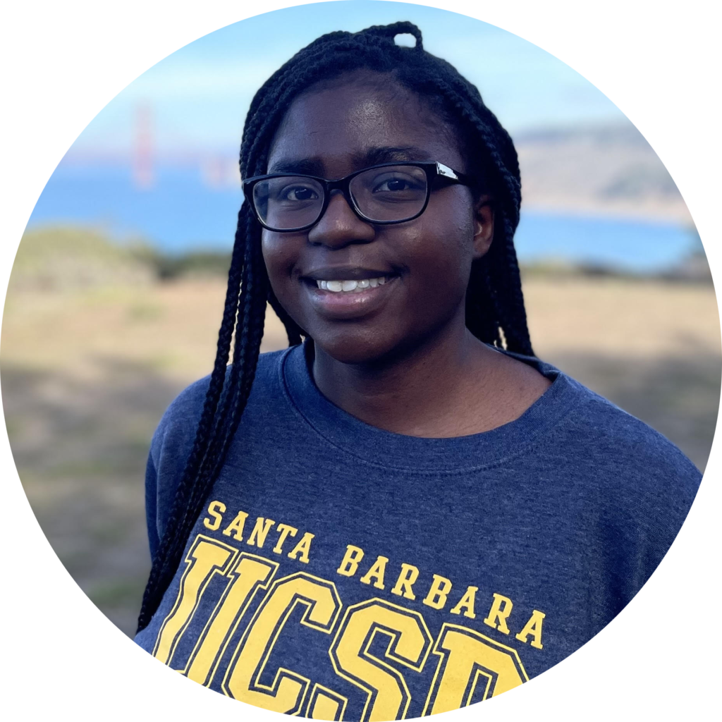 Profile picture of Grace Miller: a woman with deep brown skin and black hair in long braids. She is smiling and wearing black glasses and a heathered navy t-shirt that reads, in yellow letters, Santa Barbara UCSB.