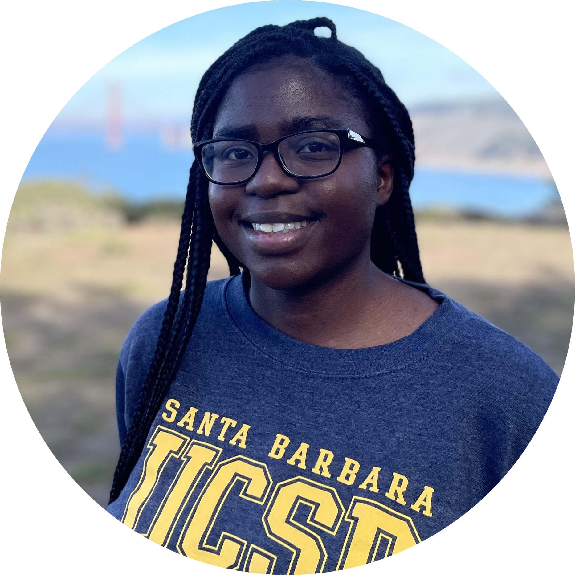 Profile picture of Grace Miller: a woman with deep brown skin and black hair in long braids. She is smiling and wearing black glasses and a heathered navy t-shirt that reads, in yellow letters, Santa Barbara UCSB.