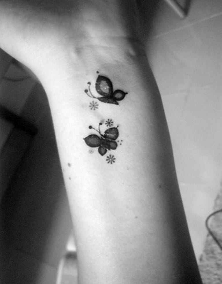 Tattoo of two small butterflies on wrist