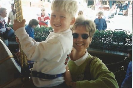 Zach as a little kid on merry-go-round with his mom