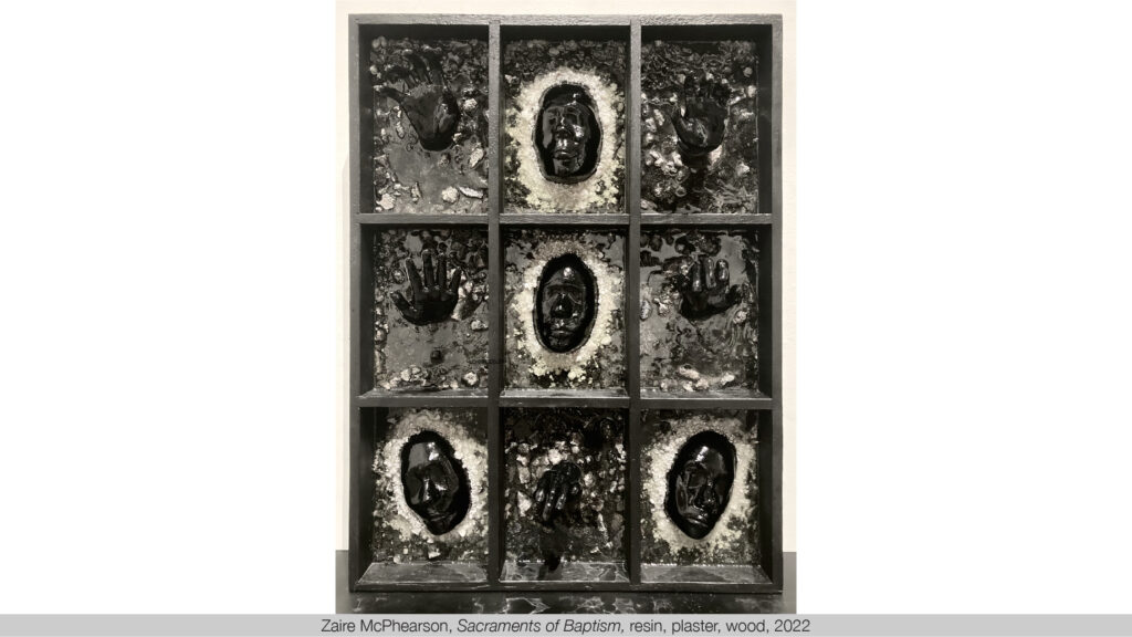 black sculptural casts of faces and hands emerging from a clear resin in a black wood 3 by 3 grid