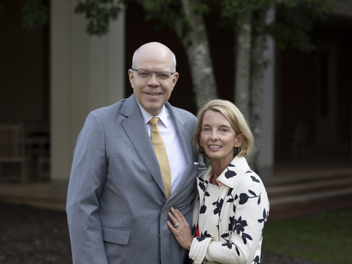 An older man and woman in formal wear posing for a picture.