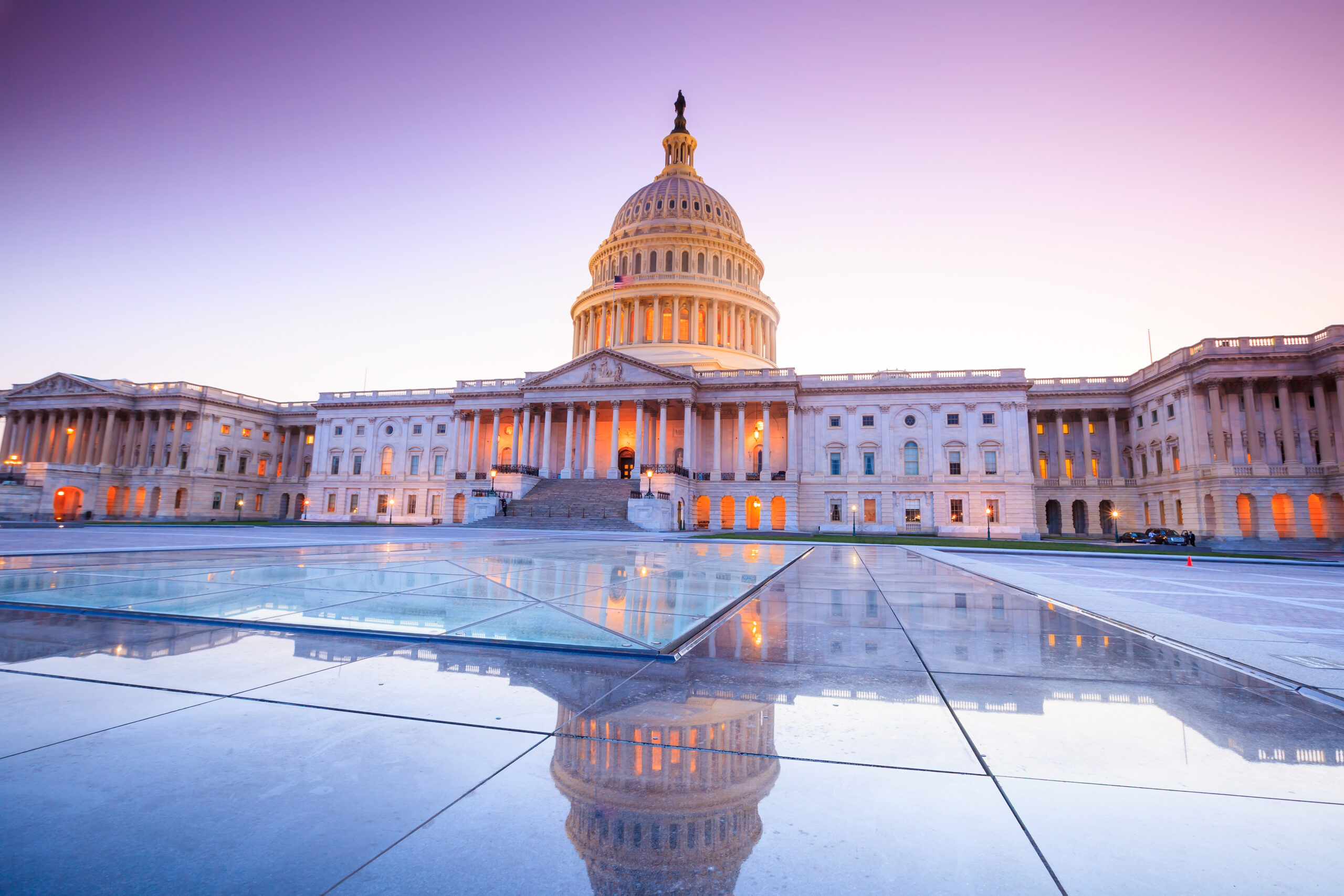 The US Capitol Building with light purple sky in the the background.