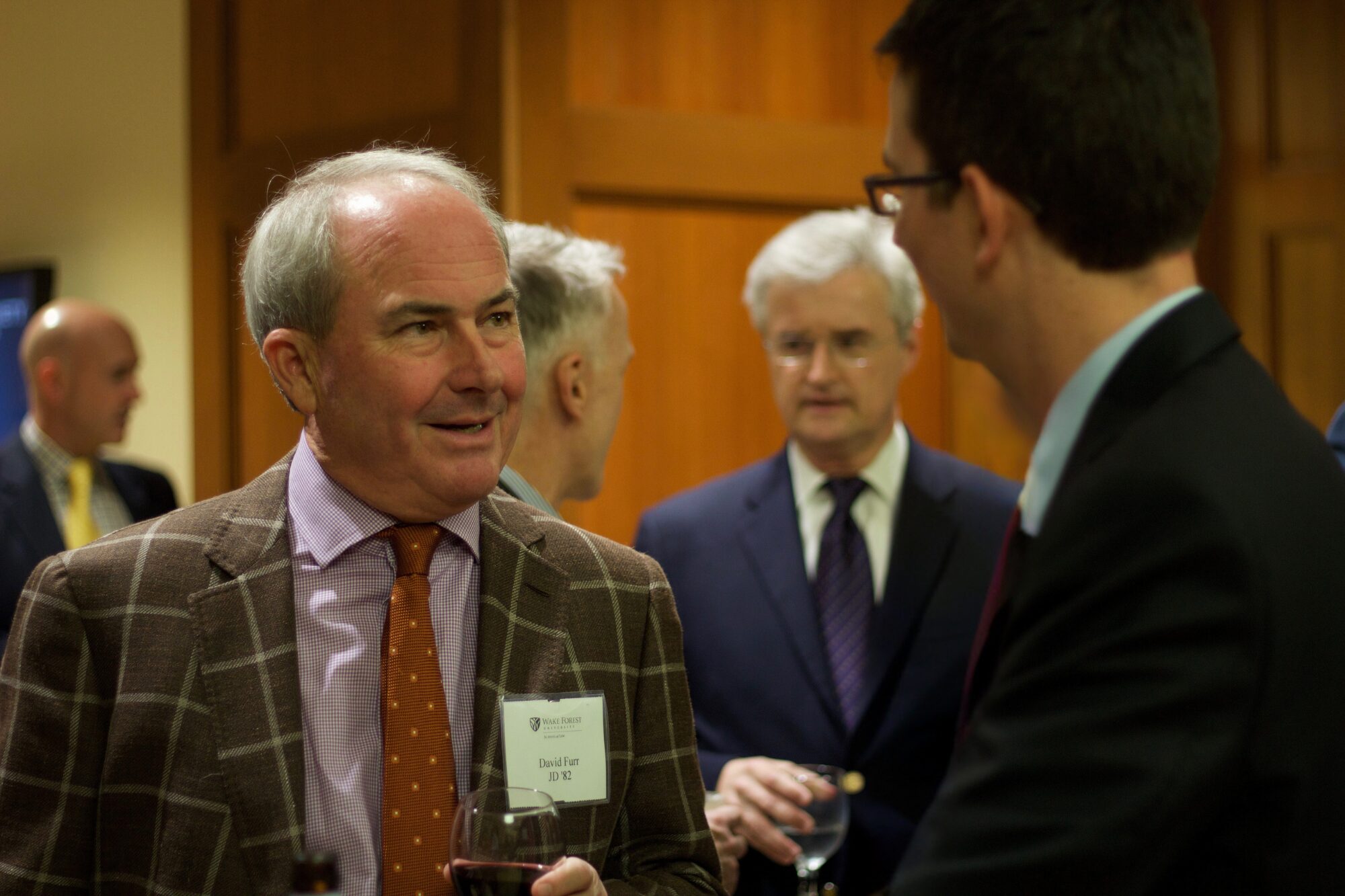 Wake Forest Law alumni David Furr dressed in formal wear speaking to another person.