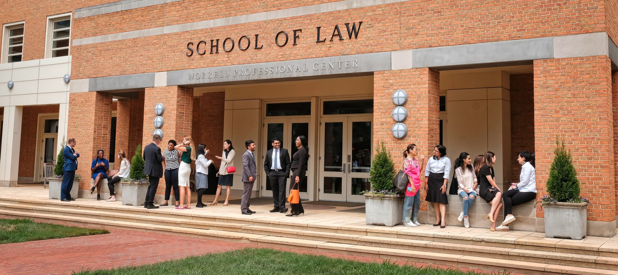 A group of students and professors speaking outside of Worrell Professional Center Building, home to Wake Forest Law.