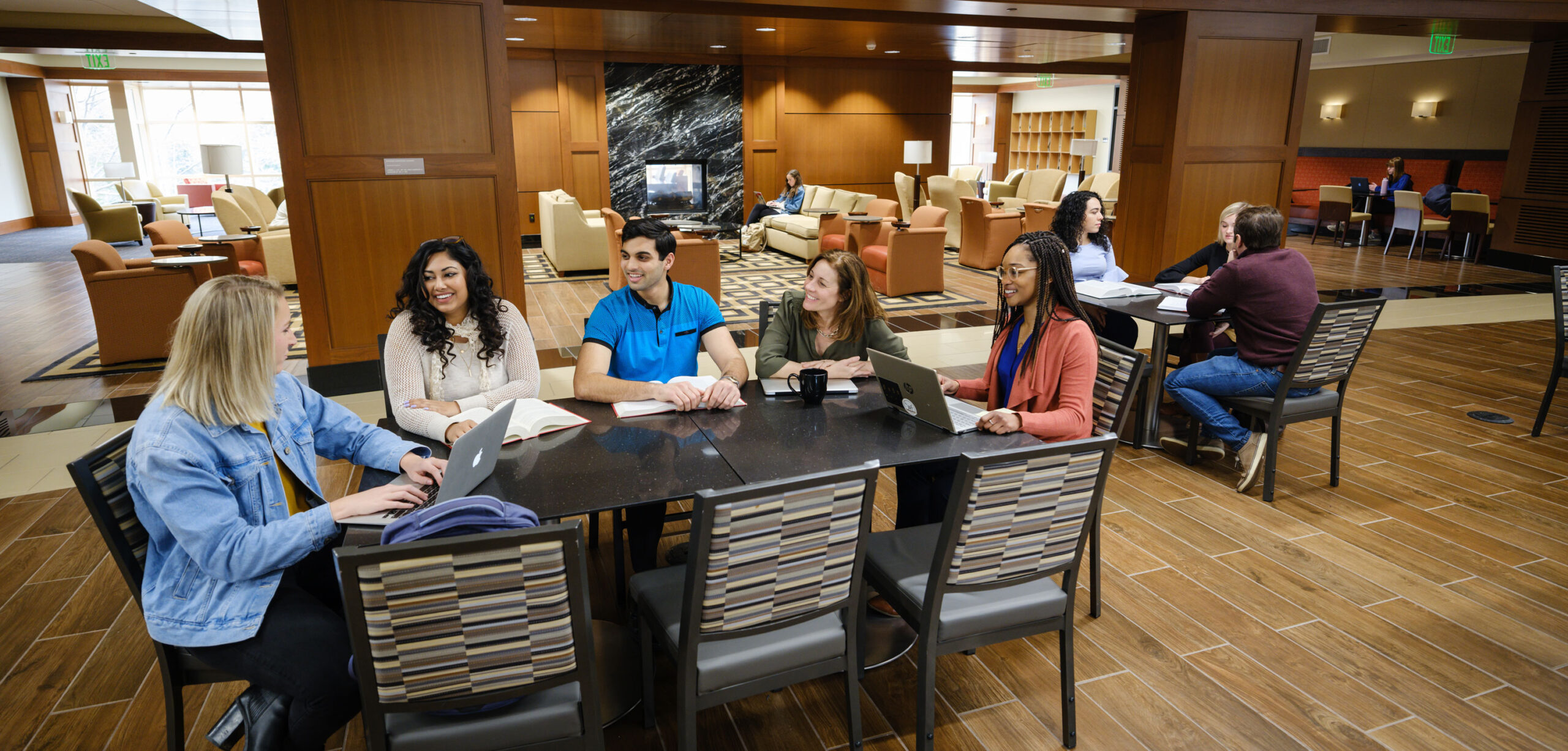 Five Wake Forest Law students having a conversation in the commons.