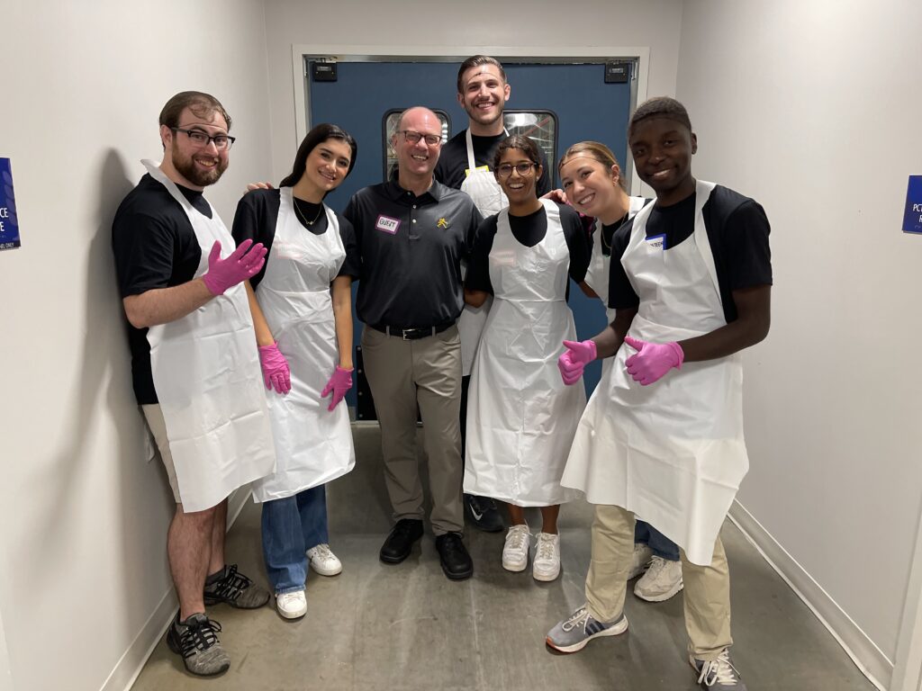 Dean Klein posing for a picture with student volunteers.