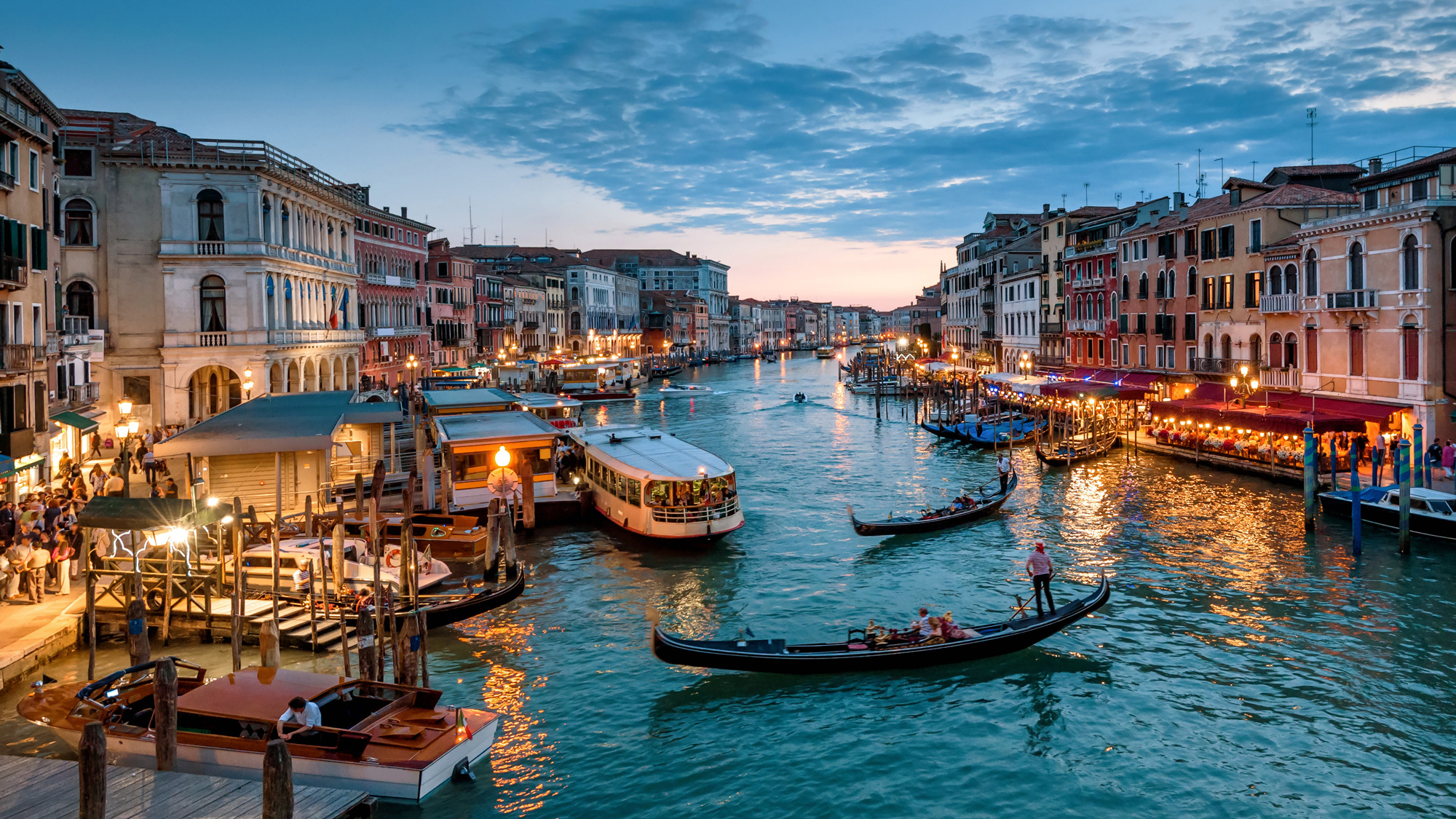 A canal in Venice, Italy during dusk.