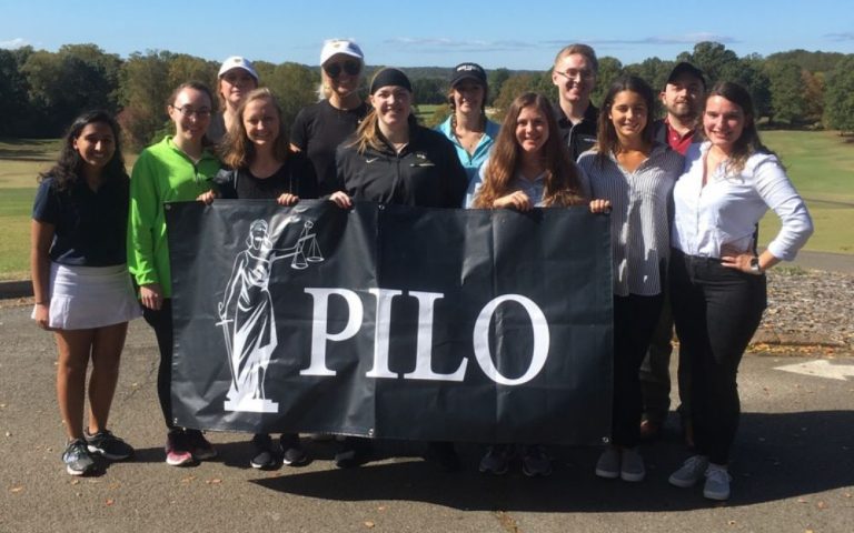 Wake Forest Law students holding a flag that reads "PILO."