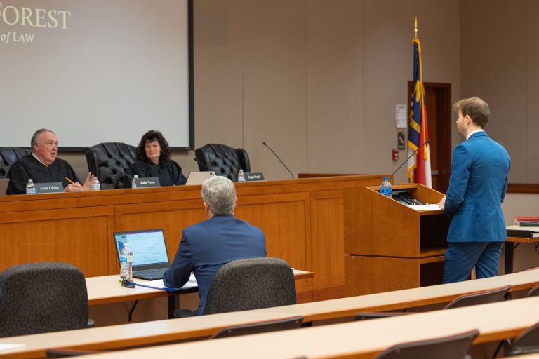 Judge John Tyson and Judge April Wood speaking to a law student.