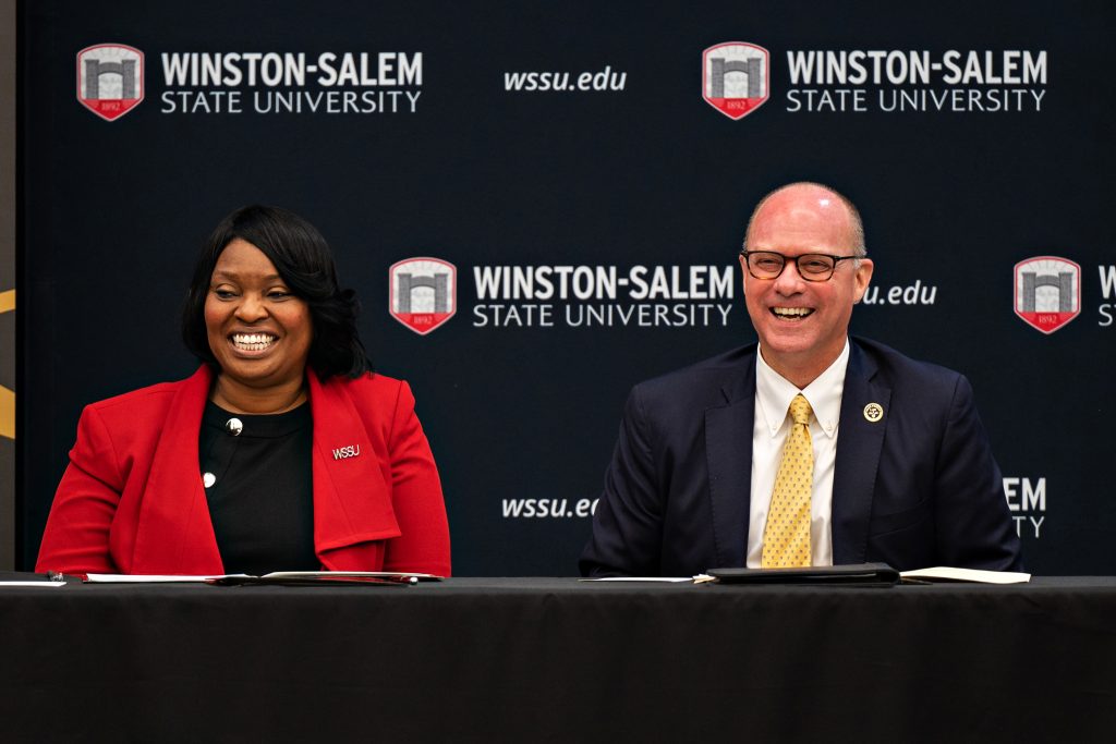 WSSU Chancellor Bonita Brown and Wake Forest Law Dean Andy Klein smile while seated on stage