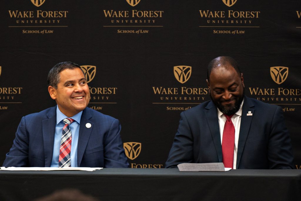 Wake Forest Chief Diversity Office Jose and WSSU Provost Anthony Graham Villalba smile while seated on stage