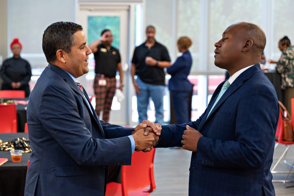 Wake Forest Chief Diversity Office Jose Villalba shakes hands with Wake Forest Law Professor Nathan Fleming