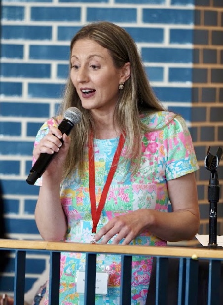 Professor Abby Perdue speaking into a microphone