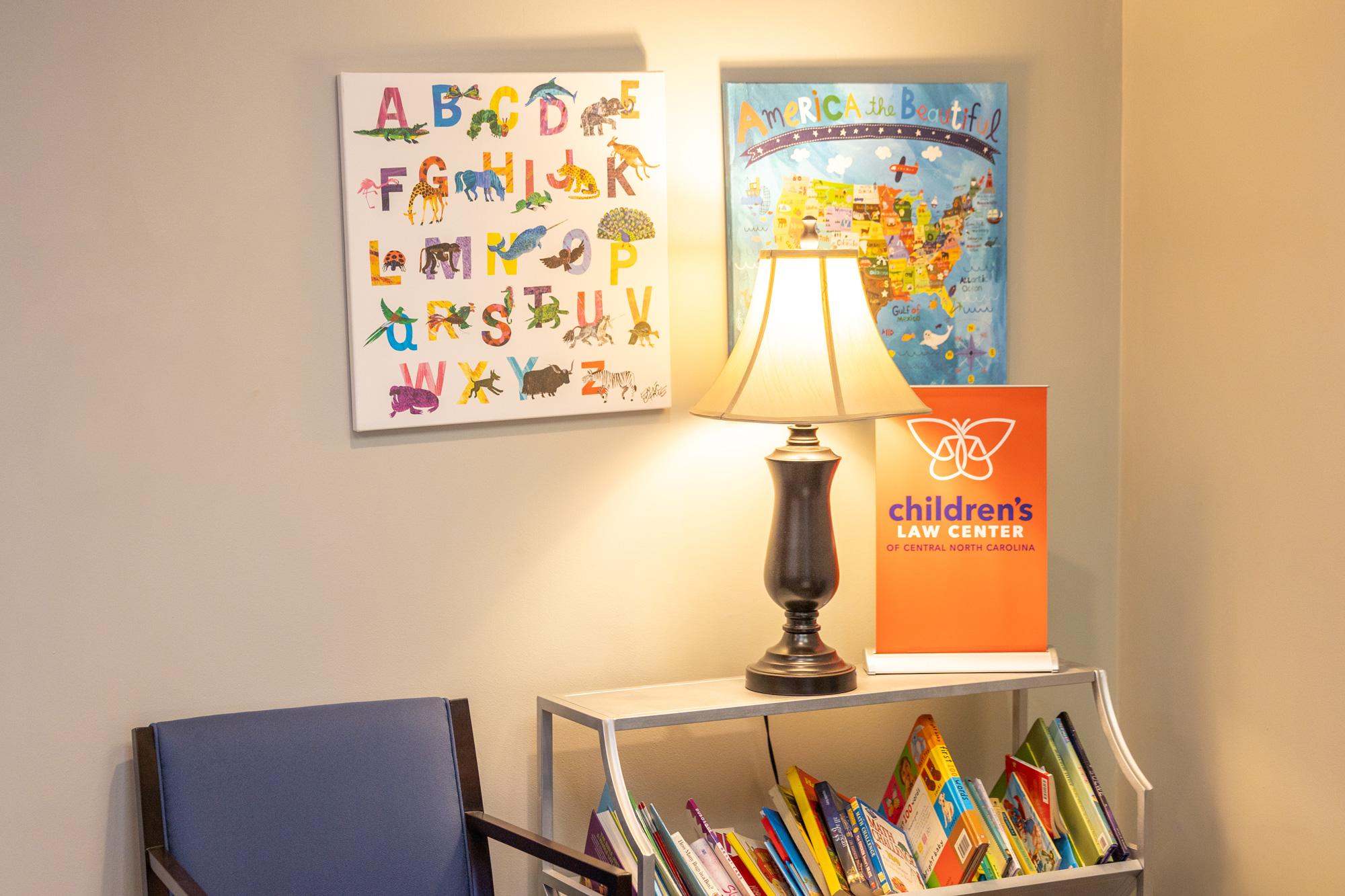 Photo of the Children's Law Center entrance lobby adorned with children's wall art, books, and warm, welcoming lighting.