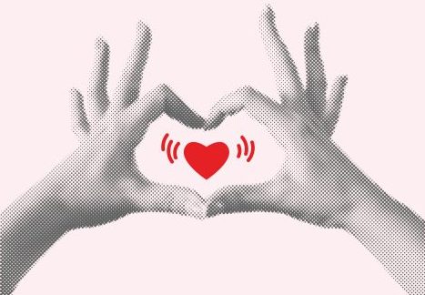 red heart framed by two hands mimicking a heart shape around it