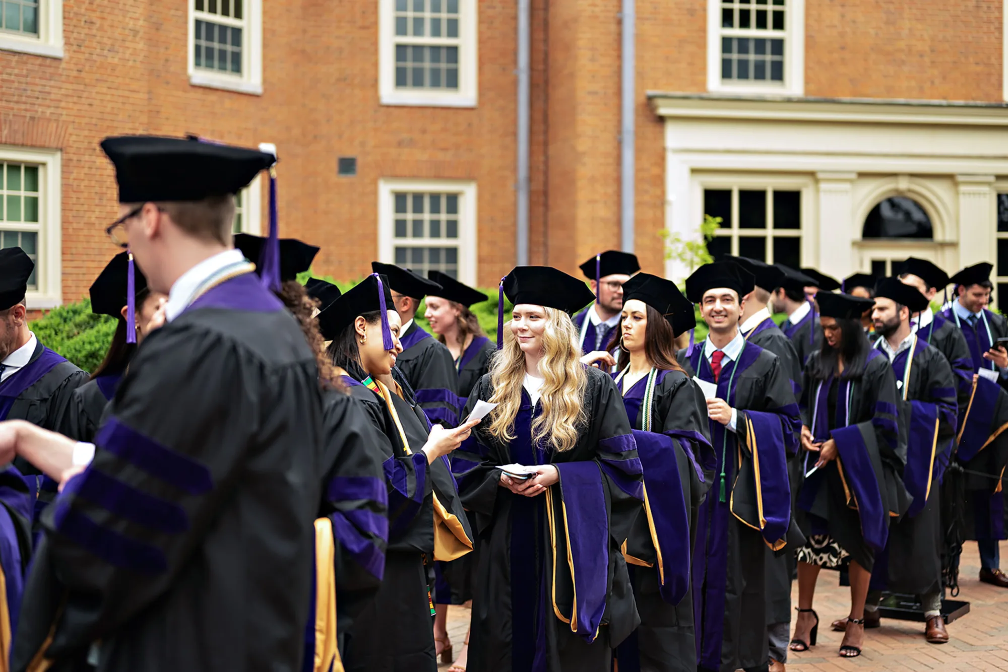 JD graduates in regalia waiting to enter Wait Chapel. 