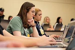 Students looking at laptops in classroom