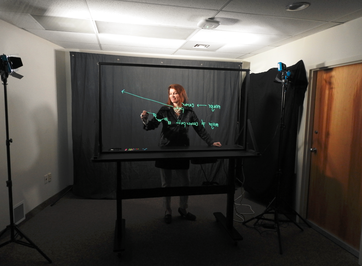 H Robinson writing on the lightboard