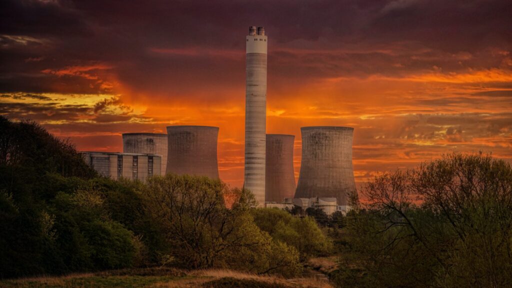 a power plant highlighted against a red foreboding sky