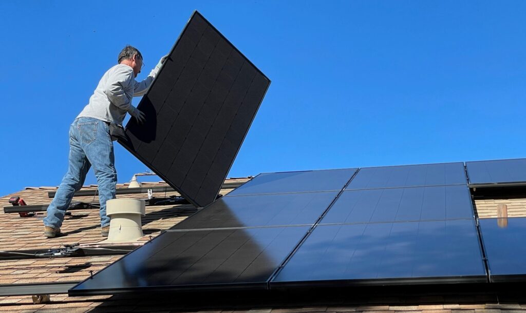 a man installing solar panels on a roof