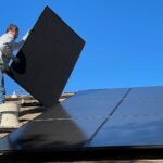 a man installing solar panels on a roof