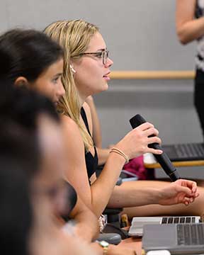 Photo of students ask questions after hearing a presentation.