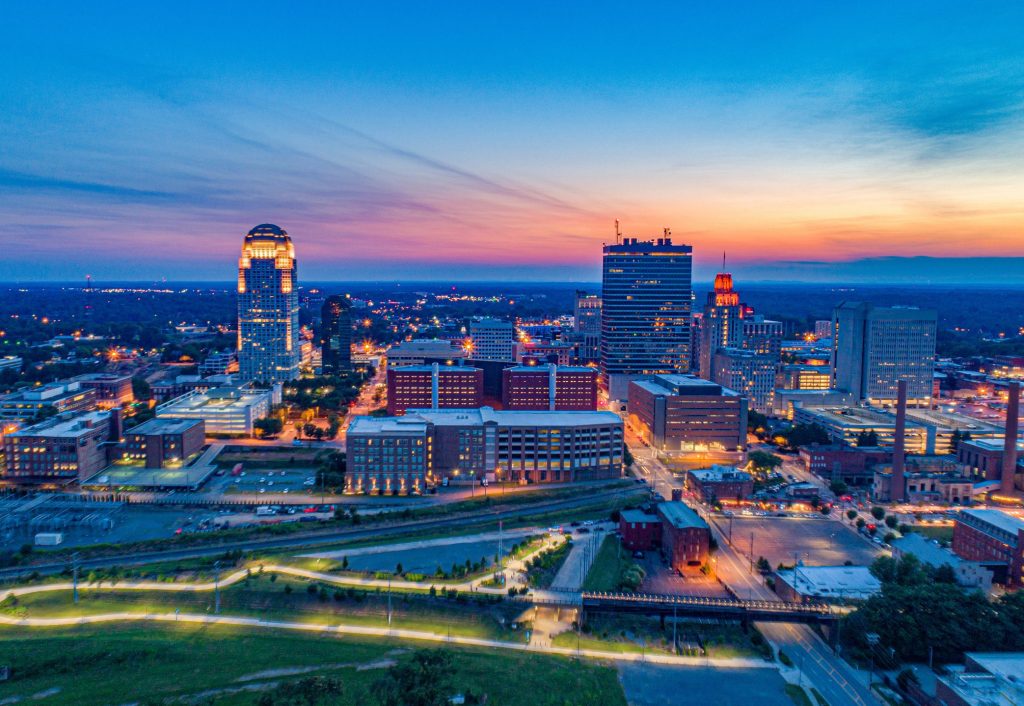 Skyline of Winston Salem at sunset, with green space in foreground