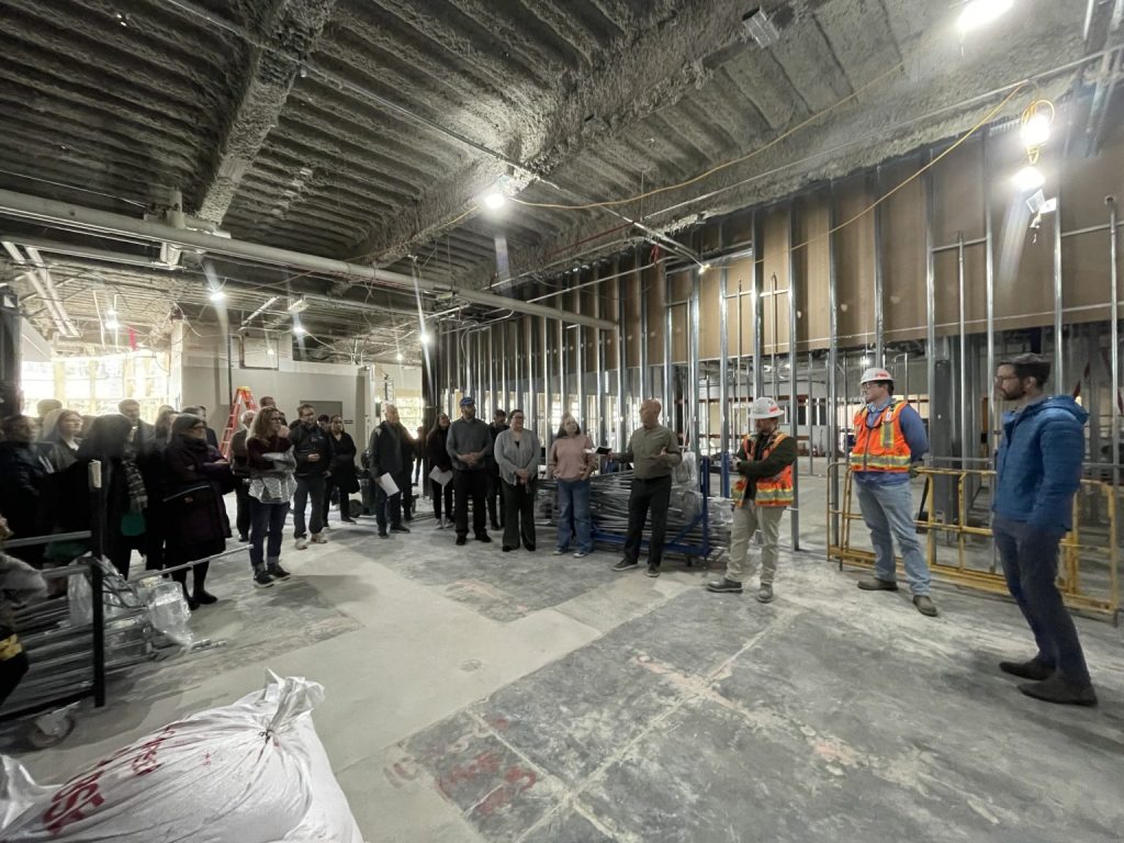 Workers stand in the husk of Alumni Hall as it is being renovated