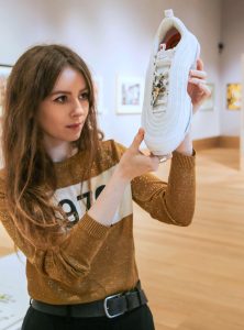 Woman holding MSCHF Jesus shoe.