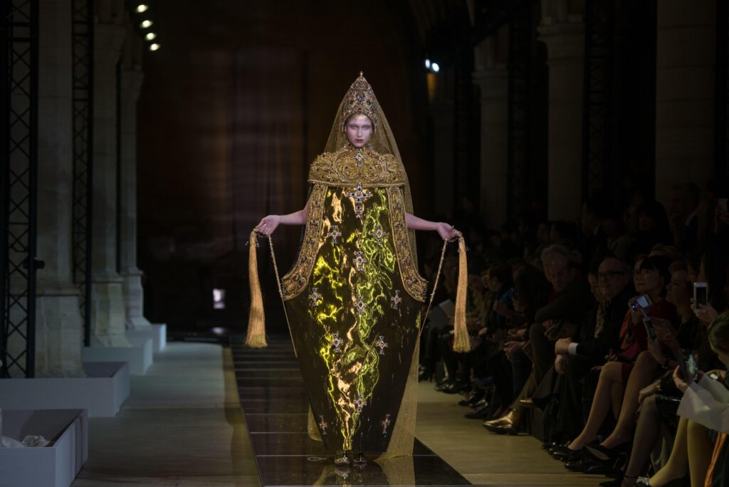 Figure 3: Model wearing Guo Pei’s thurible-inspired gown as she walks the runway--highlighting its unique structure. Photo by Alban Wyters/Abaca Press/Alamy Stock Photo.
