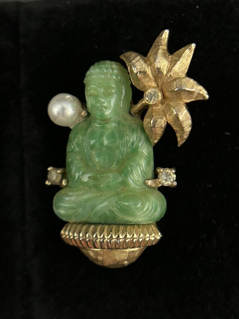 Figure 2: Close-up of J.J. Mazer brooch featuring meditating Buddha and lotus flower that was featured in the 1961 Lord & Taylor advertisement. Photo by author.